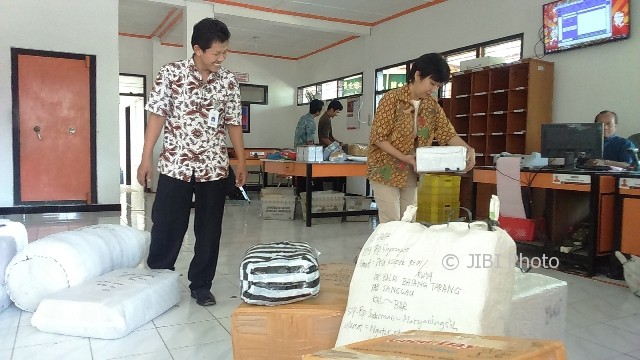 Kepala Kantor Pos Sukoharjo, Tatik Nurhayati (kanan) mengecek barang paket yang dikirim melalui kantor pos, Jumat (9/6/2017). (Trianto Hery Suryono/JIBI/Solopos)