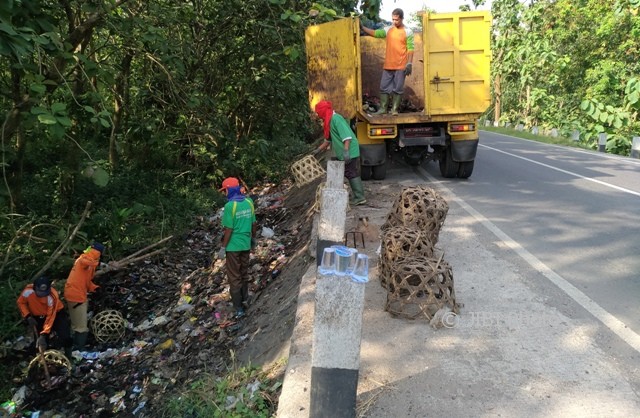 Petugas kebersihan mengangkut sampah di dekat jembatan perbatasan Selogiri, Wonogiri-Nguter, Sukoharjo, Kamis (15/6/2017). (Rudi Hartono/JIBI/Solopos)