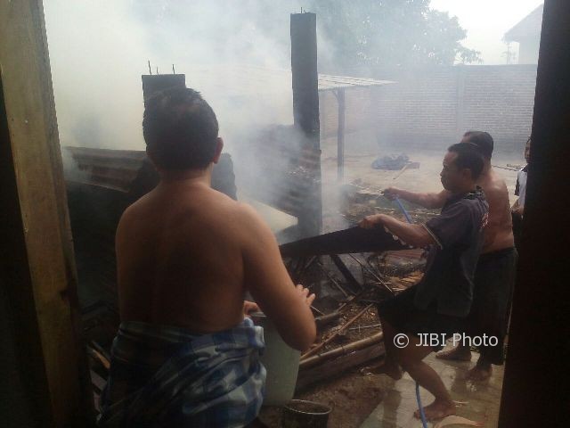 Warga mencoba memadamkan api yang membakar gudang kayu milik Murtaji di Desa Kutukulon, Kecamatan Jetis, Ponorogo, Senin (17/7/2017). (Istimewa/Polres Ponorogo)