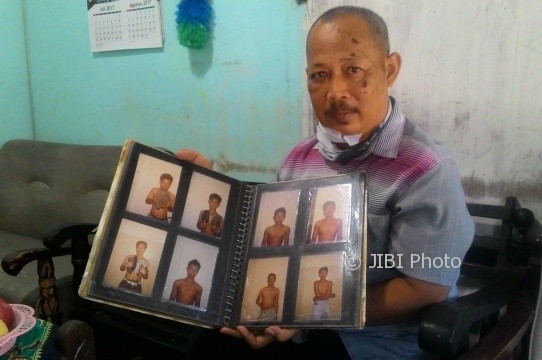 Pegawai honorer Terminal Tipe A Tirtonadi, Achmad Muhailil Churi, 53, menunjukkan foto-foto pencopet, pencuri, dan penipu yang dia tangkap di seputaran Terminal Tirtonadi Solo. (Irawan Sapto Adhi/JIBI/Solopos)