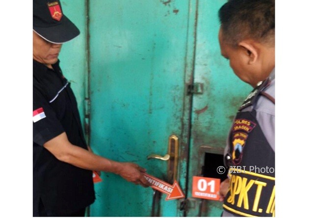 Dua polisi memeriksa kunci kios milik Sugiyono di Pasar Plupuh, Sragen, yang dibobol maling, Kamis (10/8/2017). (Istimewa/AKP Winarso)