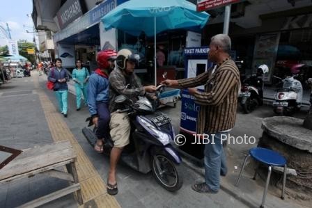Petugas parkir melayani sekaligus menyosialisasikan parkir elektronik di kawasan Jl. Gatot Subroto, Singosaren, Solo, Kamis (10/8/2017). (M. Ferri Setiawan/JIBI/Solopos)
