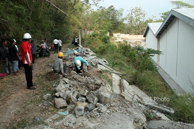 Para pekerja membongkar puing-puing pagar PT TPS Food Sragen yang ambruk akibat aksi demo ratusan warga di Dukuh Tengkikrejo, Desa Sepat, Masaran, Sabtu (12/8/2017). (Tri Rahayu/JIBI/Solopos)