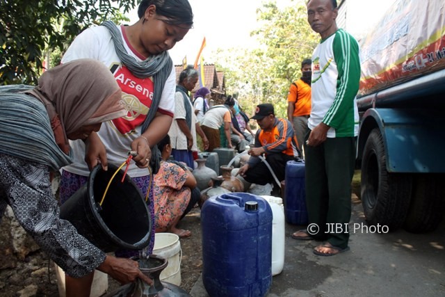 Warga menuang air ke dalam kelenting milik warga lainnya saat antre bantuan air bersih dari BPBD Sragen di Dukuh Kowang, Desa Ngargotirto, Sumberlawang, Sragen, Sabtu (12/8/2017). (Tri Rahayu/JIBI/Solopos)