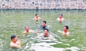 Li Zhonghua (tengah) berenang bersama enam pejabat di sebuah sungai yang dulunya tercemar (Shanghaiist)