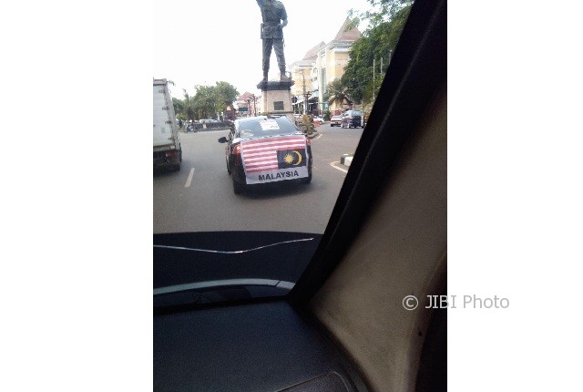 Mobil dengan spanduk bendera Malaysia terbalik tertangkap kamera di Solo (Facebook)