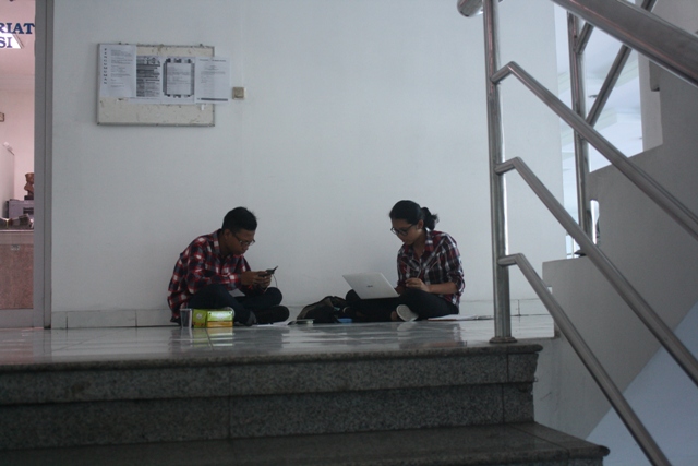 Dua peserta pelatihan dan seleksi Wasis asyik menuliskan laporan mereka seraya lesehan di koridor kantor redaksi Grup Media Solopos. (Solopos-R. Bambang Aris Sasangka)