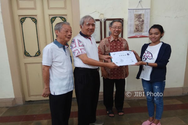 Salah satu siswa peraih sarjana pendidikan Bahasa Mandarin (kanan) menyerahkan ijazah pada Penasehat Badan Koordinasi Pendidikan Bahasa Tionghoa (BKPBT) DIY Murwadi (dua kiri) di Gedung Bhakti Loka, Jogja, Minggu (6/8/2017). (IST/dok. BKPBT)