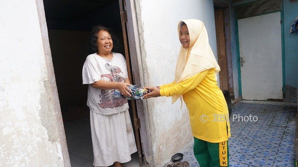 Siswa SMP Muhammadiyah 7 Jogja memberikan bingkisan kepada warga sekitar sekolah dalam rangkaian Milad sekolah tersebut ke-52, Selasa (1/8/2017). (Sunartono)