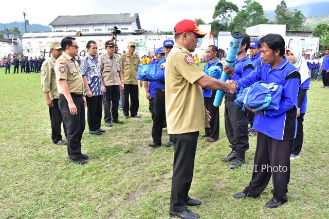 Bupati Karanganyar, Juliyatmono (topi merah), menyerahkan bantuan peralatan kepada warga Desa Girimulyo, Ngargoyoso, yang menjadi pengurus kampung siaga bencana saat pengukuhan kampung siaga bencana pada Jumat (4/8/2017). (Istimewa/Dokumentasi Dinas Kominfo Karanganyar)