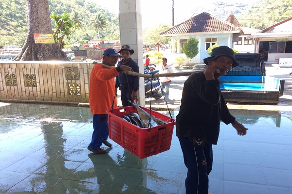 Dua nelayan sedang mengangkat hasil tangkapan ikan yang ada di TPI Pelabuhan Sadeng. Rabu (2/8/2017). (David Kurniawan/JIBI/Harian Jogja)