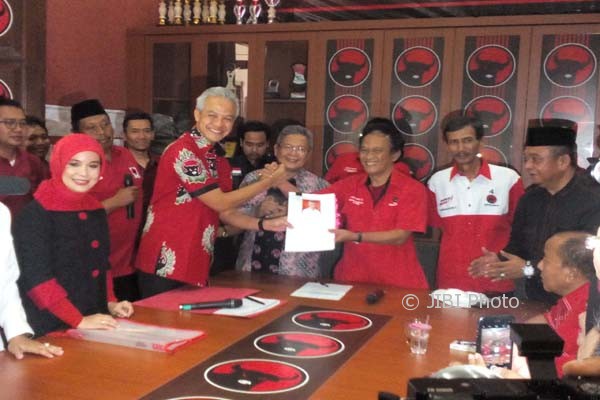 Gubernur Jateng, Ganjar Pranowo (berdiri depan kedua dari kiri) berjabat tangan dengan Sekretaris DPD PDIP Jateng, Bambang Kusriyanto, saat mengembalikan berkas formulir pendaftaran cagub dari PDIP di Kantor DPD PDIP Jateng, Semarang, Jumat (11/8/2017). (Imam Yuda S./JIBI/Semarangpos.com)