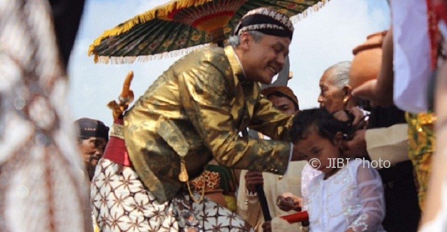 Gubernur Jateng Ganjar Pranowo memotong rambut gimbal salah satu Anak Bajang dalam acara puncak Dieng Culture Festival 2017 di Dataran Tinggi Dieng, Kabupaten Banjarnegara, Jateng, Minggu (6/8/2017). (Twitter-@kominfo_jtg)