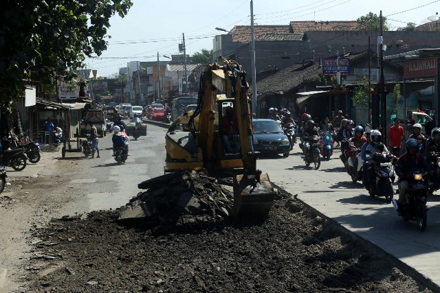 Ilustrasi: Pekerja mengeruk aspal menggunakan eskavator pada proyek perbaikan jalan. (Nicolous Irawan/JIBI/Solopos)