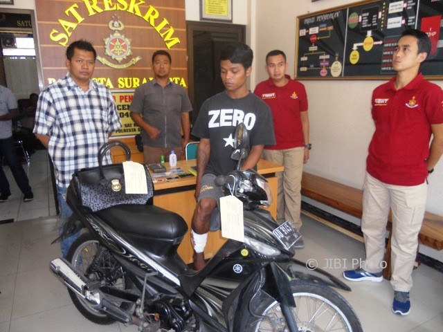 Pelaku penjambretan terhadap perempuan hamil, Anang Aji Saputro (kaos Zero), 24, warga Kampung Sewu RT 005/RW 005, Kelurahan Sewu, Jebres, Solo, Sabtu (5/8/2017), di Mapolresta Solo, menunjukkan kakinya yang masih diperban setelah ditembak polisi saat penangkapan. (Arif Fajar S./JIBI/Solopos)