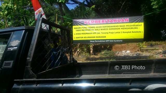 Kendaraan melintas di dekat spanduk pemberitahuan agenda pembongkaran makam TPU Putri Cempo yang dipasang Disperum KPP Solo di tepi Jl. Popda, Kelurahan Nusukan, Banjarsari, Solo, Rabu (9/8/2017). (Irawan Sapto Adhi/JIBI/Solopos)