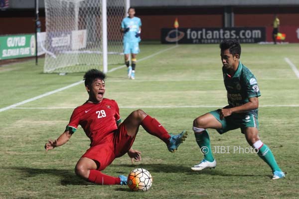Pemain TimNas U-19, Firza Andika terjatuh saat terlibat duel dengan pemain PSS Sleman, Bagsu Nirwanto pada llaga uji coba di Stadion maguwoharjo, Depok, Sleman, Sabtu (12/8) malam. (HArian JOgja/Gigih M. Hanafi)