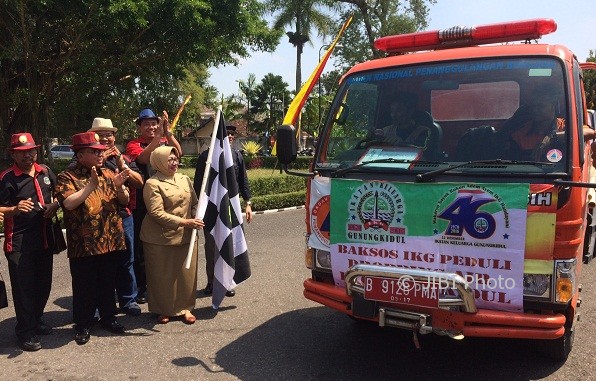 Bupati Gunungkidul, Bandingah mengibarkan bendera start saat sejumlah mobil tangki pengangkut air hendak mendistribusikan air ke sejumlah warga yang terdapak kekeringan, Senin (7/8/2017). (Foto Istimewa)