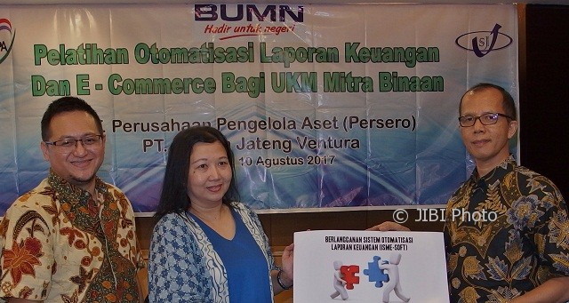 GM Corporate Secretary & Legal Council PT Perusahaan Pengelola Aset Edi Winanto (kanan) didampingi Dirut PT Sarana Jateng Ventura Jarot Wahyu Wibowo (kiri) secara simbolis menyerahkan kartu berlangganan Sistem Otomatisasi Laporan Keuangan kepada pengusaha suvenir pernikahan Tri Meiyanti (tengah) pada pembukaan Pelatihan Otomatisasi Laporan Keuangan dan E-Commerce Bagi UKM Mitra Binaan, di Kota Semarang, Jateng, Kamis (10/8/2017). (JIBI/Solopos/Antara/R. Rekotomo)