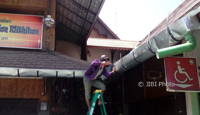 Pekerja memasang talang di Pasar Triwindu Solo sisi depan, belum lama ini. (Bayu Jatmiko Adi/JIBI/Solopos)