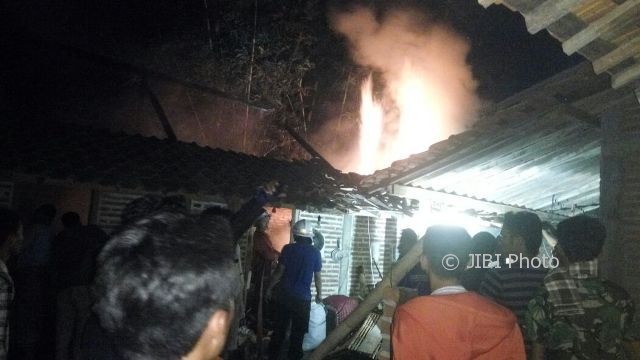 Warga melihat kobakaran api yang membakar rumah Jeminah, warga Desa Golan, Kecamatan Sukorejo, Ponorogo, Senin (7/8/2017) malam. (Istimewa/Polres Ponorogo)