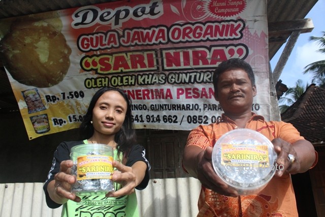 Kepala Dusun Dringo Desa Gunturharjo, Wonogiri, Juwani, dan penjual gula jawa organik Sari Nira, Eni Lisnawati, menunjukkan gula jawa organik Sari Nira yang menjadi oleh-oleh khas di kawasan pantai Nampu, Wonogiri, Kamis (3/8/2017). (Ahmad Wakid/JIBI/Solopos)
