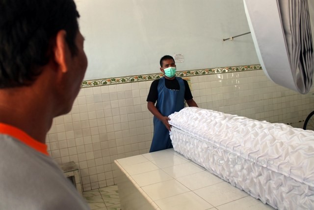 Seorang penjaga kamar mayat (kanan) menyiapkan peti jenazah korban tabrak lari asal Sambungmacan, Andi Prasetyo, 17, di RSUD dr. Soehadi Prijonegoro Sragen, Jumat (8/9/2017). (Tri Rahayu/JIBI/Solopos)
