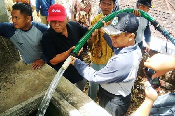 Wakil Bupati Gunungkidul Immawan Wahyudi (pegang selang) saat memberikan bantuan air bersih kepada warga di Desa Banjarejo, Kecamatan Tanjungsari, Senin (11/9/2017). (David Kurniawan/JIBI/Harian Jogja)