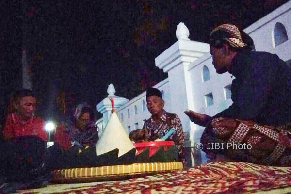 Peziarah didampingi oleh salah satu juru kunci berdoa sebagai ungkapan rasa syukur pada malam satu Suro, Rabu (20/9/2017) di kompleks Cepuri Parangkusumo. (Rheisnayu Cyntara/JIBI/Harian Jogja)