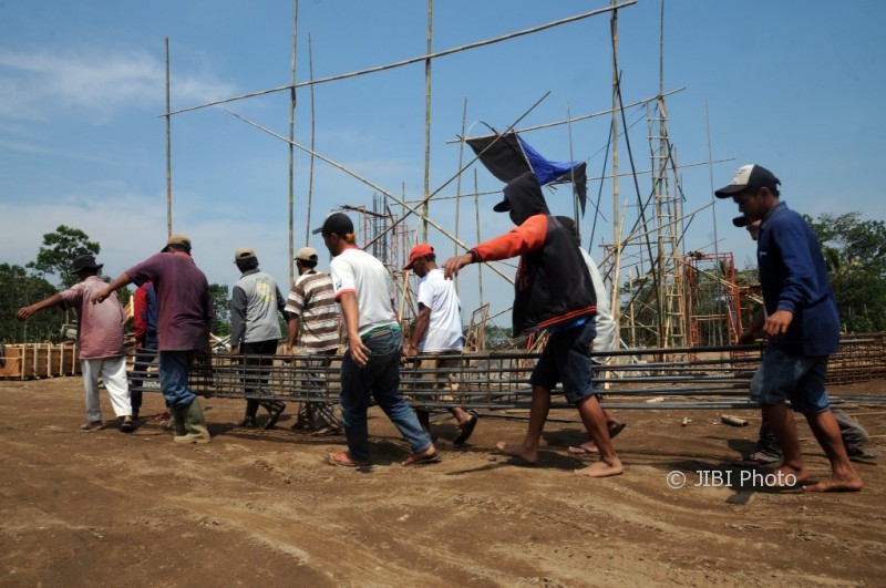Pekerja mengusung besi dalam pembangunan Pasar Hewan Desa Jelok, Kecamatan Cepogo, Boyolali, Senin (2/10/2017). (Istimewa/Dok. Pemkab Boyolali)