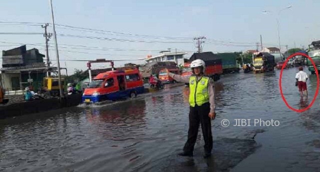 Siswa SD (dalam lingkaran) yang terpotret menerjang banjir di Genuk, Kota Semarang, Jateng pada Hari Kesaktian Pancasila, Minggu (1/10/2017). (Instagram-@santlantaspolrestabessmg)