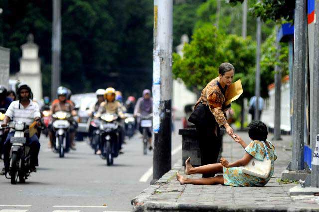 TARGET -- Seorang warga memberi sedekah kepada seorang pengemis di pinggir Jalan Jenderal Sudirman, Solo, beberapa waktu lalu. DPRD Jateng mempertanyakan kinerja Pemprov yang dinilai gagal memeunhi target pengurangan kemiskinan. (JIBI/SOLOPOS/Dwi Prasetya)