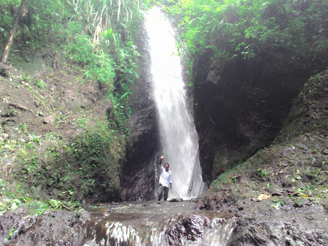 Sekretaris Desa Anggras Manis, Jenawi, Karanganyar, Sutarno, berada di bawah air terjun Ringin Jenggot yang berada sekitar 4 kilometer dari permukiman warga, Rabu (25/3/2015). Air terjun tersebut saat ini sedang diupayakan untuk menjadi objek wisata alam di Karanganyar. (Bayu Jatmiko Adi/JIBI/Solopos)