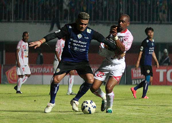 Pesepak bola Persipura Lancine Kone (putih) berebut bola dengan pesepak bola Arema Cronus Cristian Gonzales pada babak delapan besar Piala Jenderal Sudirman, di Stadion Maguwoharjo, Sleman, beberapa waktu lalu. (JIBI/Harian Jogja/Jumali)