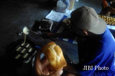 -Seorang warga memasukkan adonan roti kolombeng ke dalam loyang cetakan di sebuah rumah produksi di Dusun Diran, Desa Sidorejo, Kecamatan Lendah, Kulonprogo, Selasa (18/10/2016) pekan lalu. (Rima Sekarani I.N./JIBI/Harian Jogja).