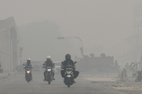 Pengendara kendaraan bermotor melintas di jalan Soekarno Hatta ketika kabut asap pekat dampak karhutla menyelimuti Kota Pekanbaru, Riau, Selasa (17/9/2019). (Antara/Rony Muharrman)
