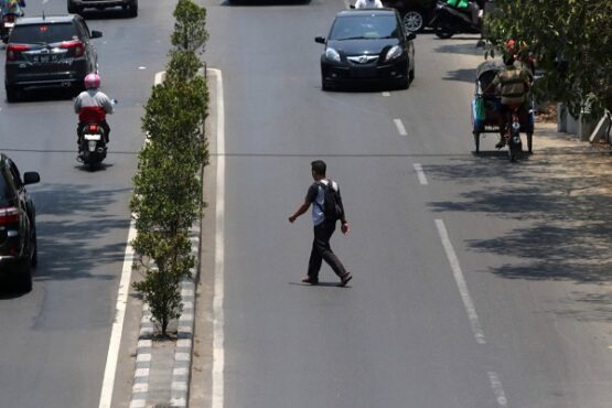 Warga menyebrangi Jl. Kolonel Sutarto, Jebres, Solo, saat proses kulminasi matahari berlangsung, Kamis (10/10/2019). (Solopos/Nicolous Irawan)