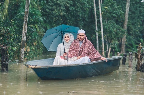 Pengantin di Narathiwat, Thailand yang melangsungkan resepsi pernikahan di tengah banjir, Minggu (1/12/2019). (Facebook-Meen Photographer)