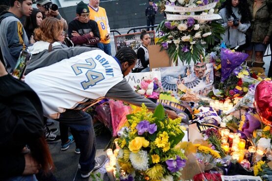 Sejumlah penggemar manaruh bunga dan lilin tanda penghormatan kepada Kobe Bryant di Microsoft Square, Los Angeles, AS, Minggu (26/1/2020) malam waktu setempat. (Reuters-Kyle Grillot)