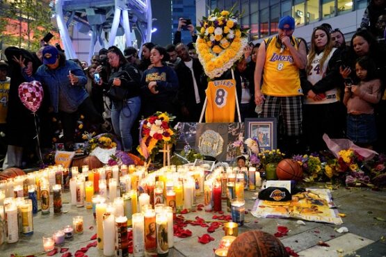 Sejumlah penggemar manaruh bunga dan lilin tanda penghormatan kepada Kobe Bryant di Microsoft Square, Los Angeles, AS, Minggu (26/1/2020) malam waktu setempat. (Reuters-Kyle Grillot)