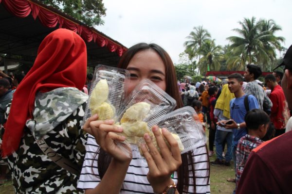 Warga menunjukkan buah durian yang berhasil didapatkan saat digelar Festival Durian di Lapangan Desa Randulanang, Kecamatan Jatinom, Minggu (2/2/2020). (Solopos/Taufiq Sidik Prakoso)