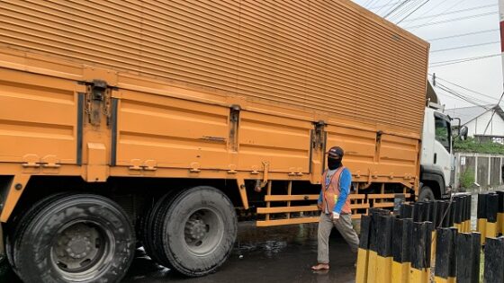 Supeltas Tri Setiawan mengatur lalu lintas kendaraan di pintu perlintasan kereta api JPL 107 Dagen, Jaten, Karanganyar Jumat (7/2/2020). (Solopos/Candra Mantovani)