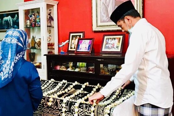 Presiden Joko Widodo (Jokowi) merapikan karangan bunga di peti jenazah ibunya, sudjiatmi notomihardjo