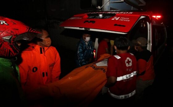 Petugas Badan Penanggulangan Bencana Daerah (BPBD) Kota Solo bersama petugas Palang Merah Indonesia (PMI) Kota Solo dibantu warga mengevakuasi jenazah untuk dinaikan ke ambulance di Jogobayan, Setabelan, Banjarsari, Solo, Selasa (7/4/2020) malam. (Nicolous Irawan/Solopos)