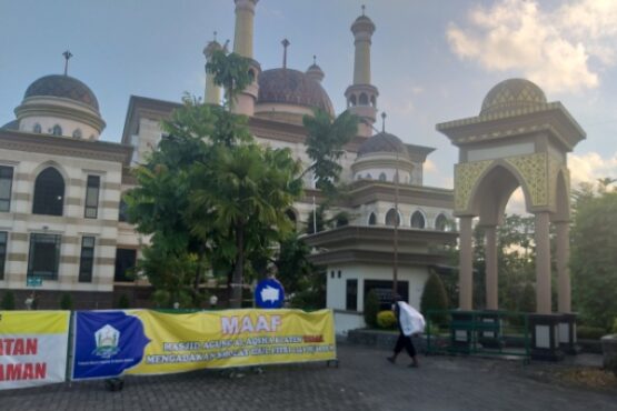Warga melintas di dekat spanduk jumbo yang intinya menerangkan dua masjid besar di Klaten tidak menyelenggarakan Salat Id, Minggu (24/5). Dua masjid besar itu, yakni Masjid Raya Klaten dan Masjid Al Aqsha Klaten. (Ponco Suseno/Solopos)