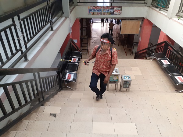 Seorang petugas menyemprot cairan disinfektan di tangga Pasar Ir Soekarno, Sukoharjo, Jumat (12/6/2020). (Solopos/Bony Eko Wicaksono)