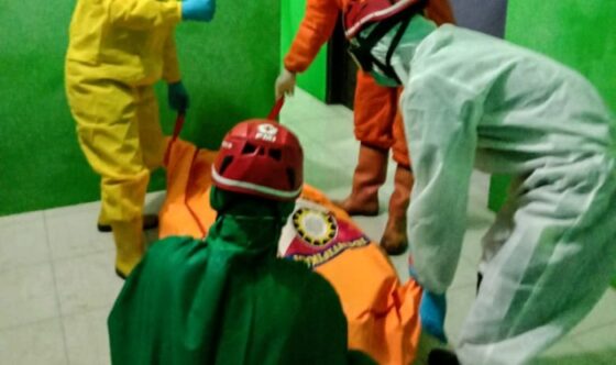 Empat orang petugas yang mengenakan hazmat dan alat pelindung diri lengkap mengevakuasi jenazah yang ditemukan di sebuah rumah di Bangun Asri, Plumbungan, Karangmalang, Sragen, Senin (12/10/2020) malam. (Khusus-BPBD Sragen)