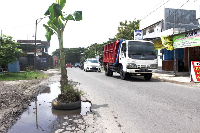 Pohon pisang ditanam pada lubang jalan yang tergenang air di Jl Sragen-Balong km 7 Ngarum, Ngrampal, Sragen, Minggu (14/2/2021). (Solopos/Tri Rahayu)