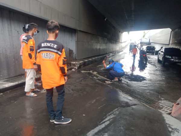 Petugas Satlantas Pos Kartasura bersama sukarelawan memperbaiki penutup saluran drainase underpass Makamhaji, Kartasura, Sukoharjo, yang rusak lagi meski baru sehari diperbaiki, Jumat (5/2/2021). (Solopos/Indah Septiyaning W)
