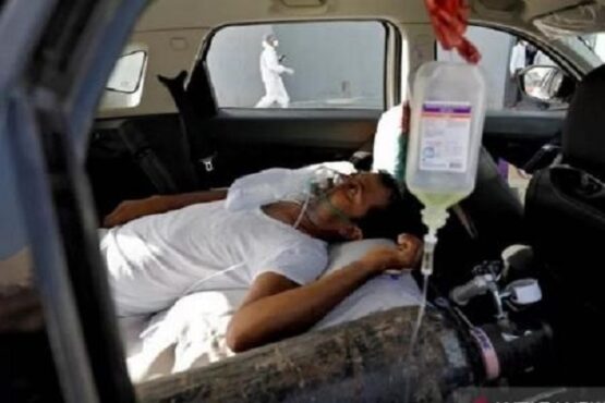 pasien gangguan pernapasan di dalam mobil menunggu untuk dirawat di rumah sakit Covid-19 untuk perawatan, di tengah penyebaran virus corona di Ahmedabad, India,